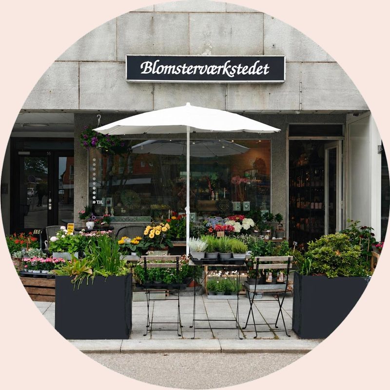 Blomsterværkstedets butik på Torvegade i Faxe med blomster foran døren